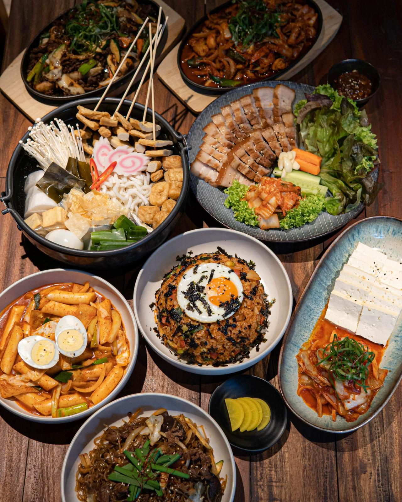 Holztisch mit mehreren asiatischen Gerichten