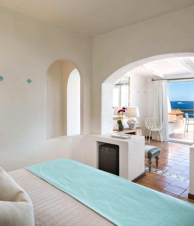 Schlafzimmer im Club Hotel Baja Sardinia mit Blick auf das Meer.
