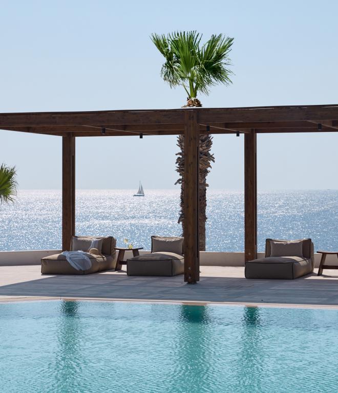 Pool im Elissa Lifestyleresort: Pool mit überdachter Liefefläche und Luegebetten. Im Hintergrund sieht man das Meer.