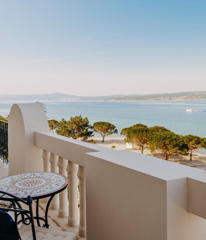 Blick auf Balkon des Hotel Miramare mit rundem Tisch und Stühlen und Blick aufs Meer
