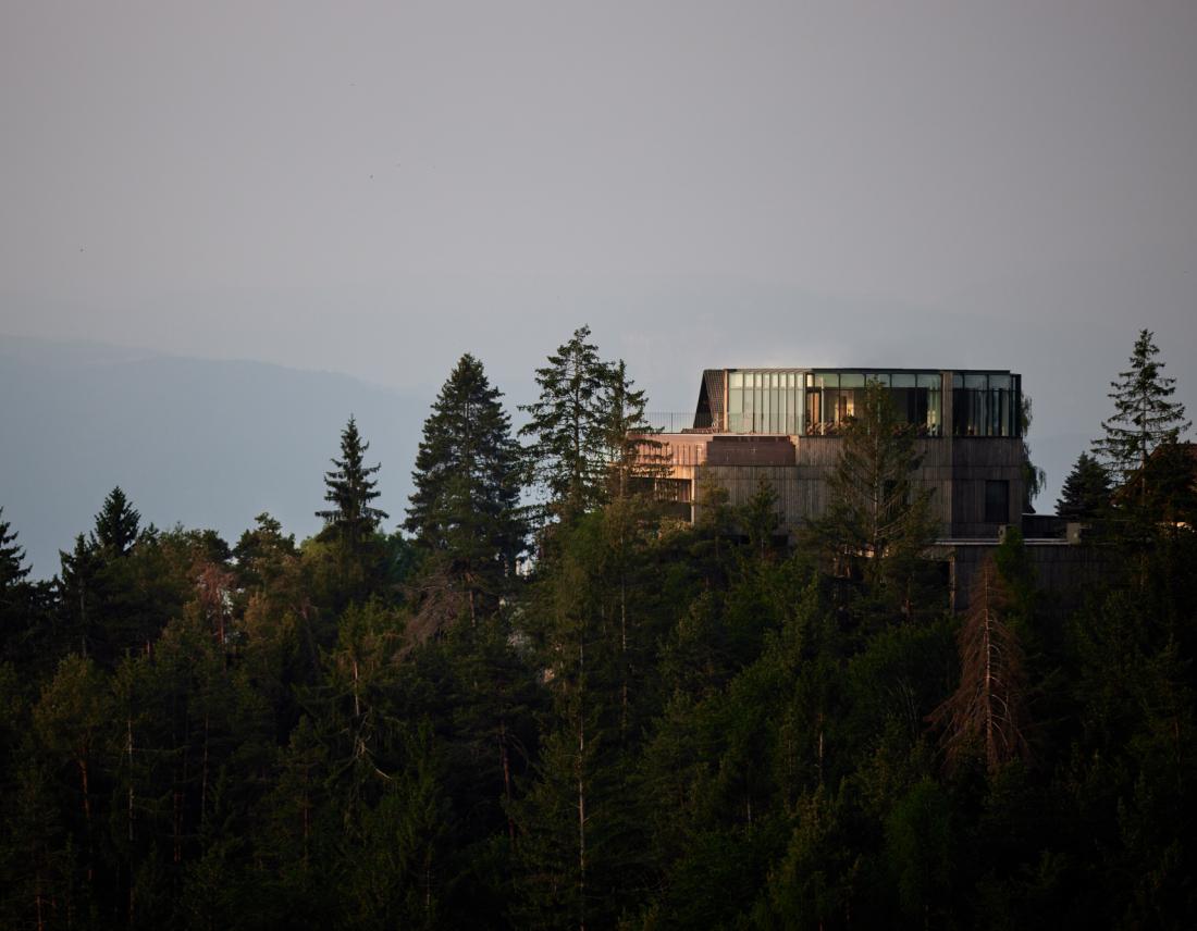 Waldhügel mit einem modernem Gebäude auf der Spitze