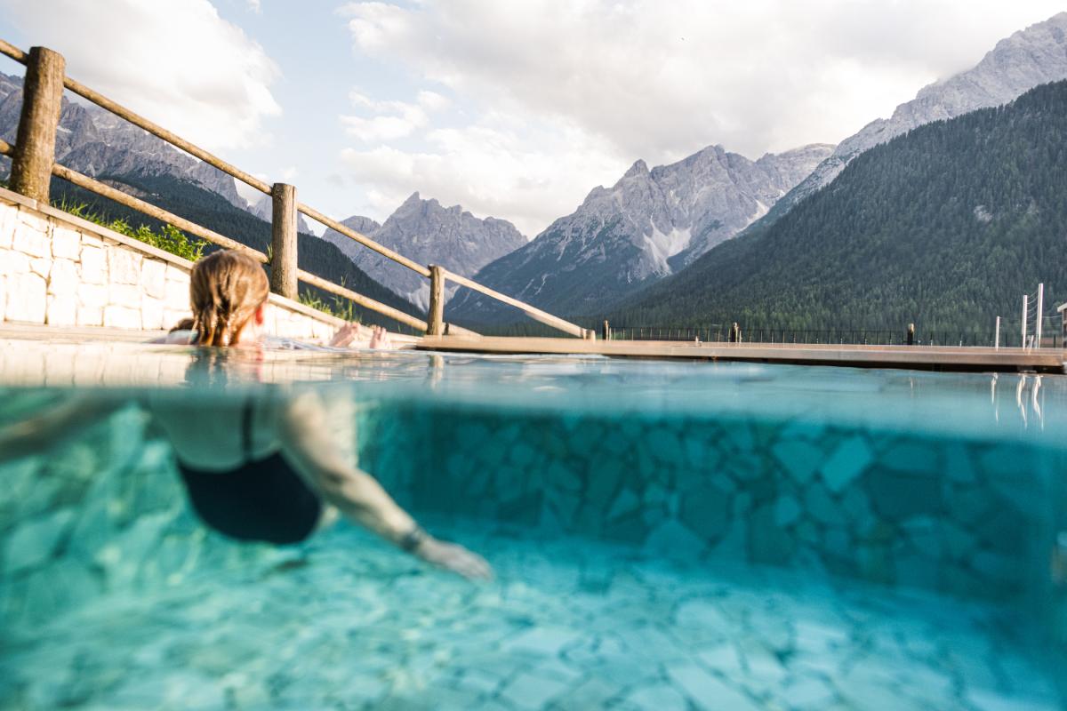 Frau in einem Pool mit Bergblick