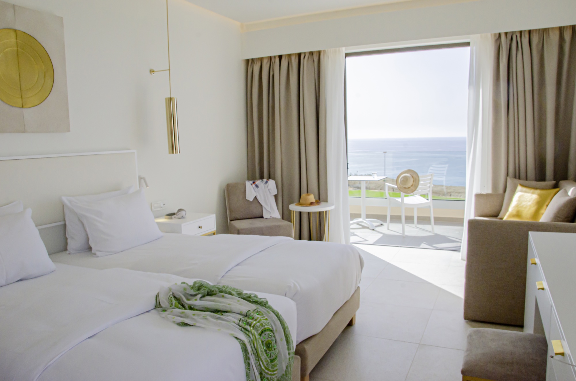 Hotelzimmer mit Doppelbett und offener Terrassentür mit Blick aufs Meer