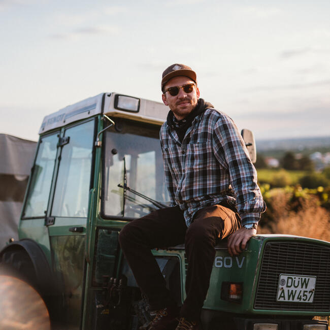 Vincent Eymann, der auf einem Traktor sitzt in den Weinbergen