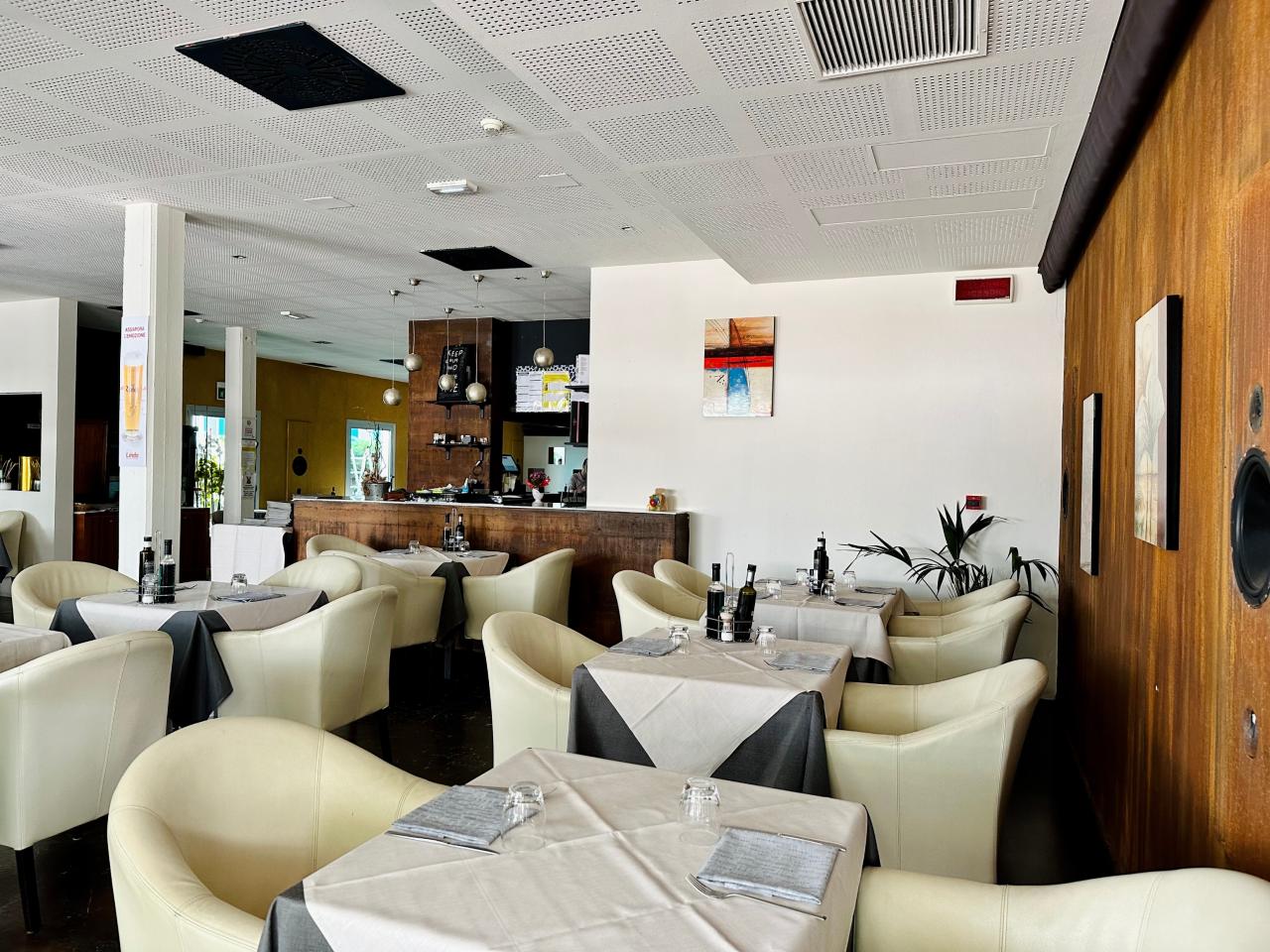 Restaurant Rojz Innenansicht: Raum mit weißen Tischen und weißen Sesseln