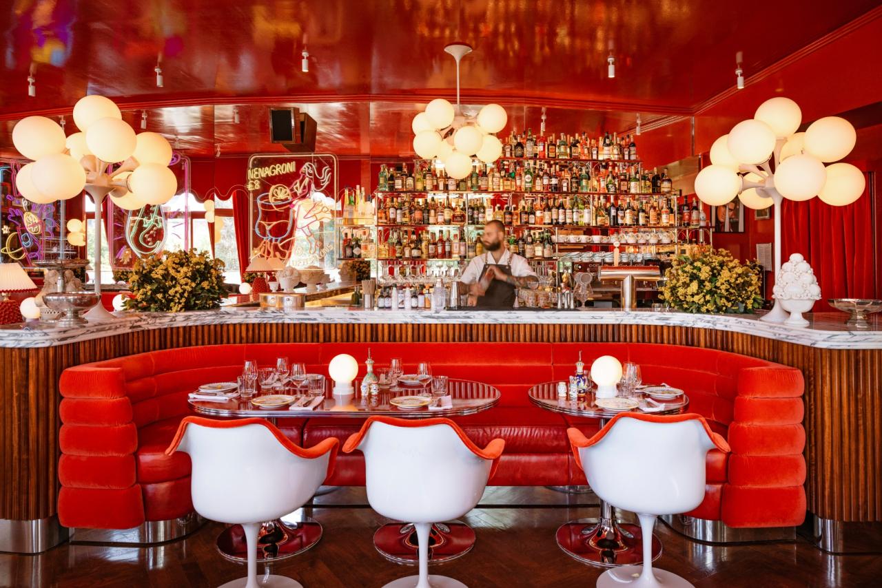 Rote Bar mit weißen Stühlen und Lichtern