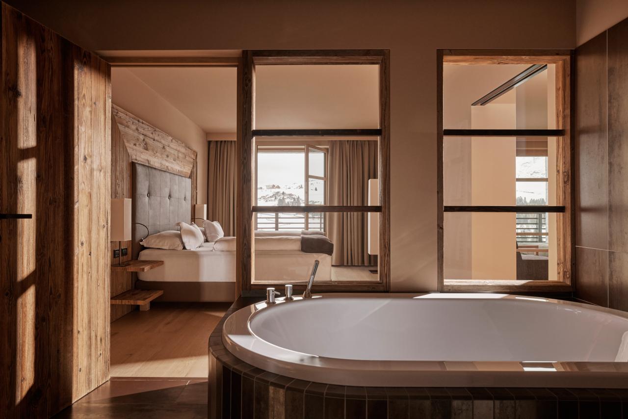 Freistehende Badewanne mit Doppelbett im Hintergrund
