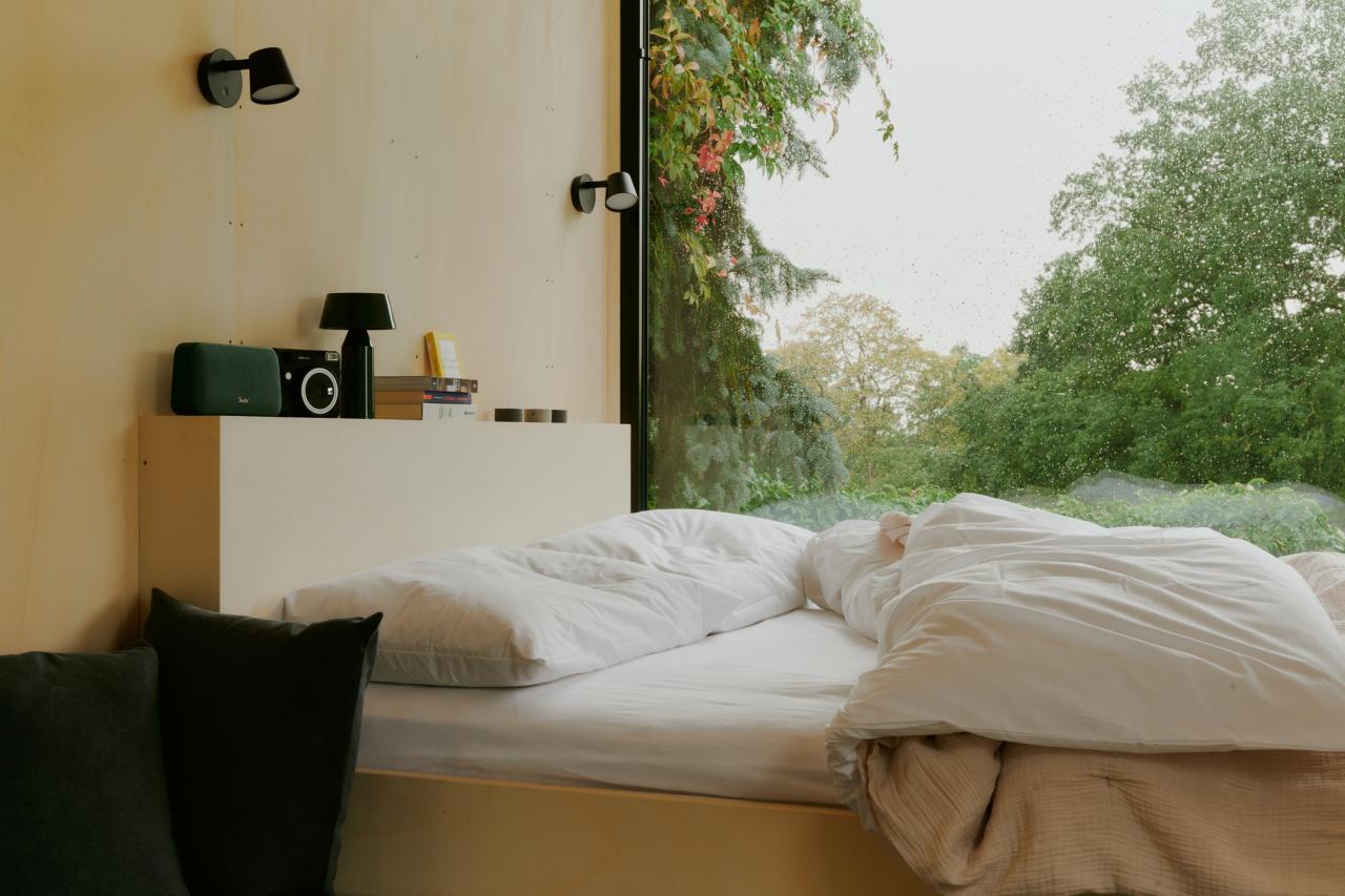 Bett mit Panoramafenster ins Grüne