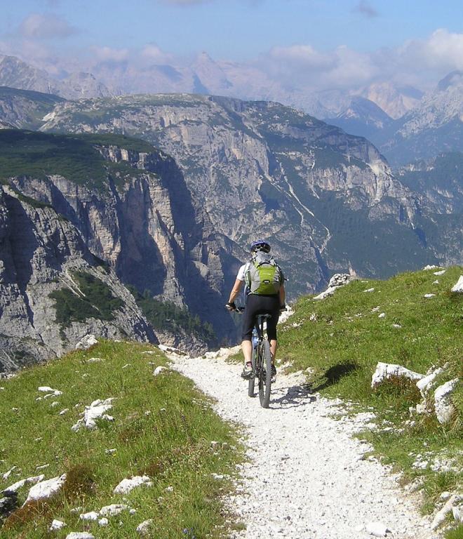 Radfahrer auf einem Radweg in den Bergen: Mountainbike-Touren in den Dolomiten