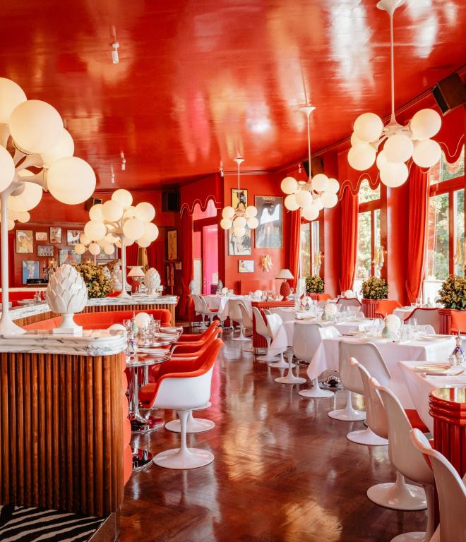 Restaurant mit roten Wänden und weißen Tischen und Stühlen