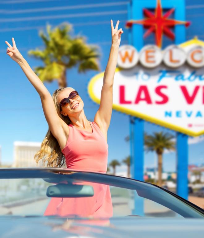 Frau in einem Cabrio vor einem Las Vegas Schild