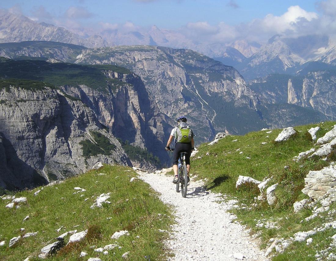 Radfahrer auf einem Radweg in den Bergen: Mountainbike-Touren in den Dolomiten