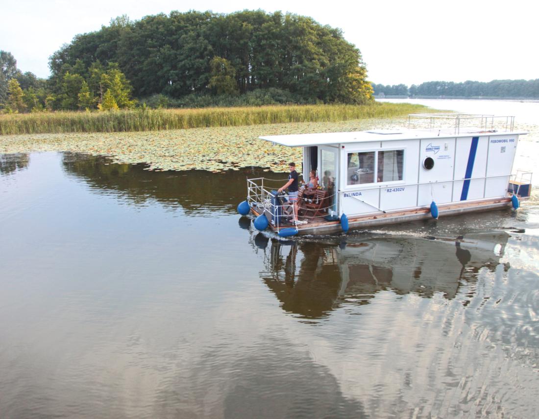 Hausboot mit kleiner Terrasse auf einem Fluss