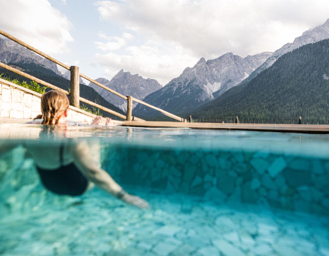 Frau in einem Pool mit Bergblick