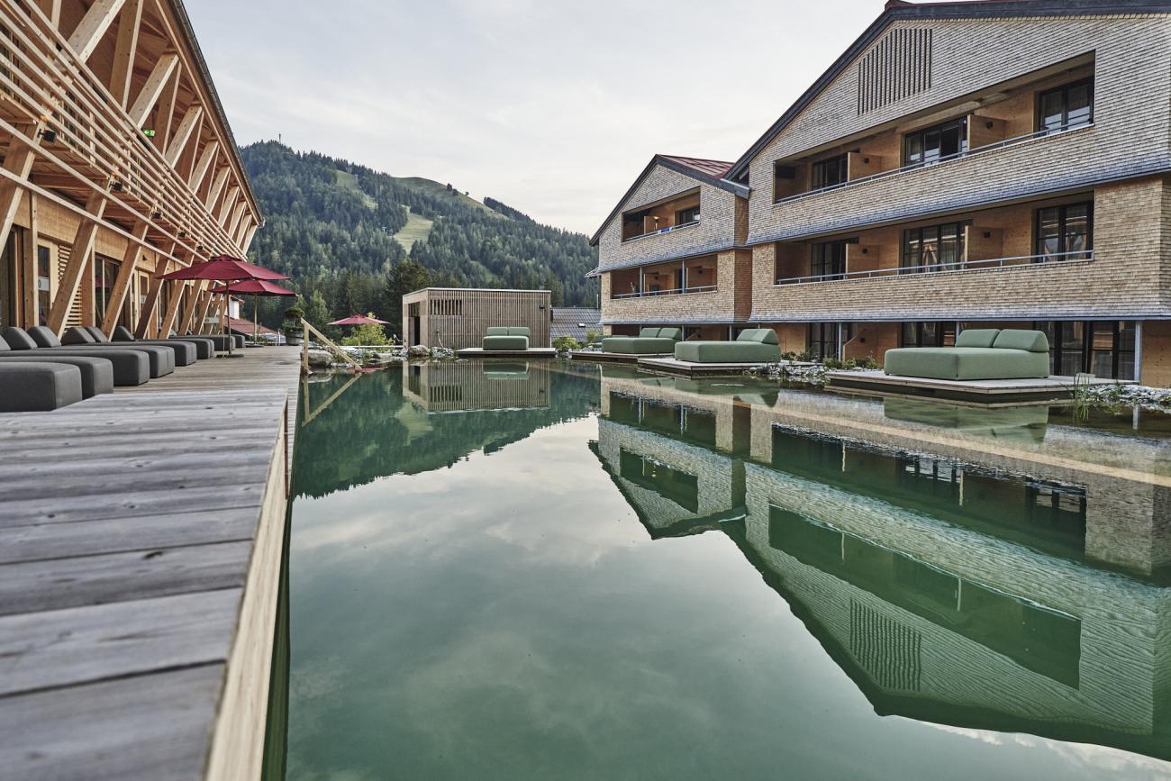 Holzhotel mit Naturbadeteich in der Mitte