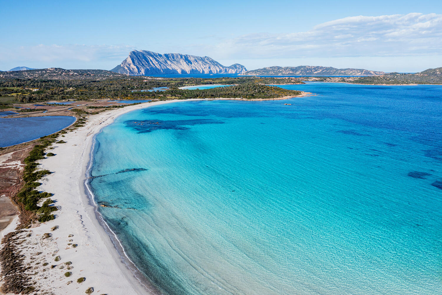Blick auf weißen Sandstrand mit türkisem Meer in Sardinien am Baglioni Resort