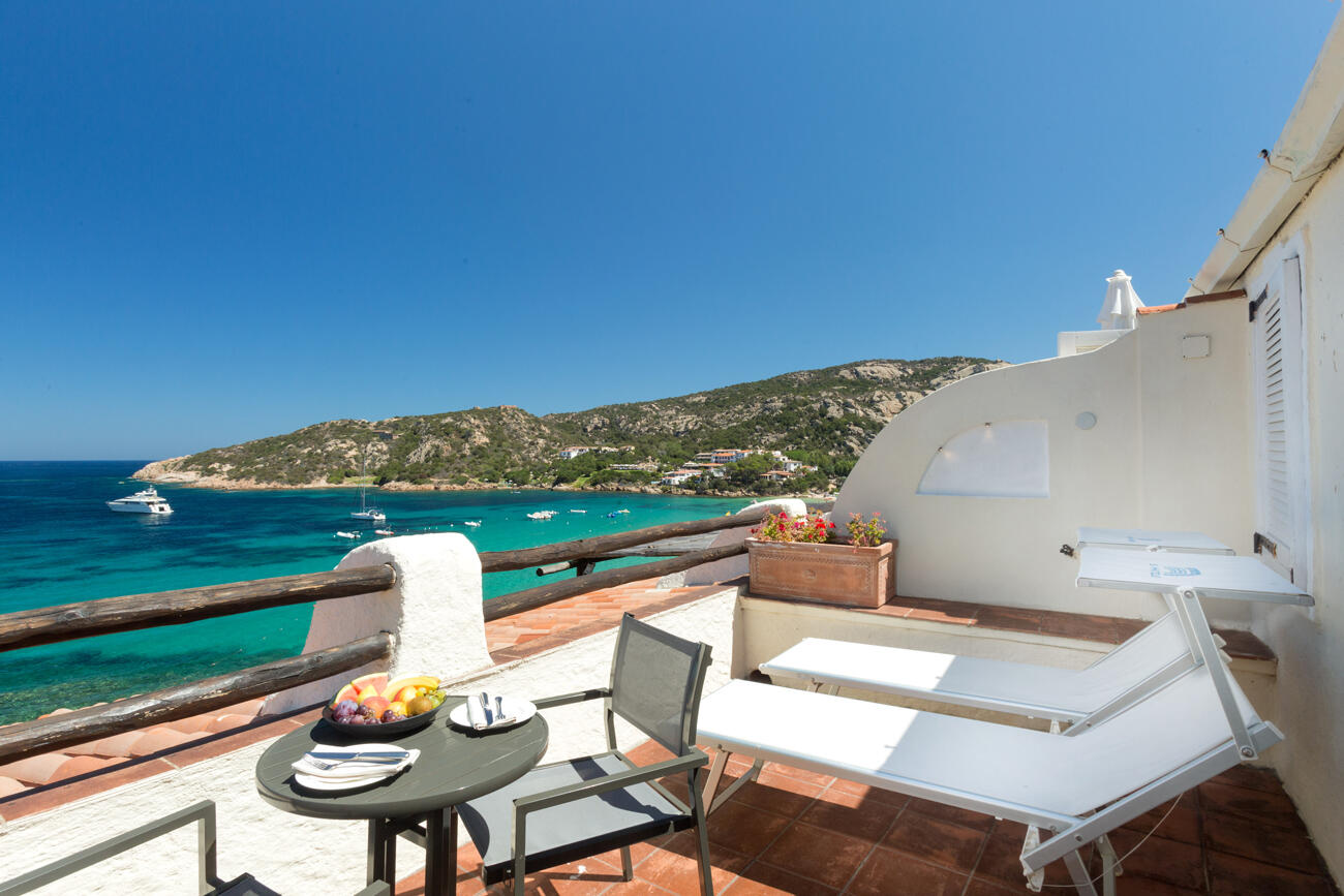 Terrasse mit zwei Liegestühlen und Blick auf das Meer in Sardinien