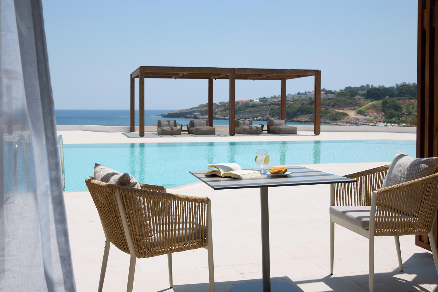 Elissa Lifestyle Resort: Terrasse mit Pool, Sitzmöglichkeit und Blick auf das Meer