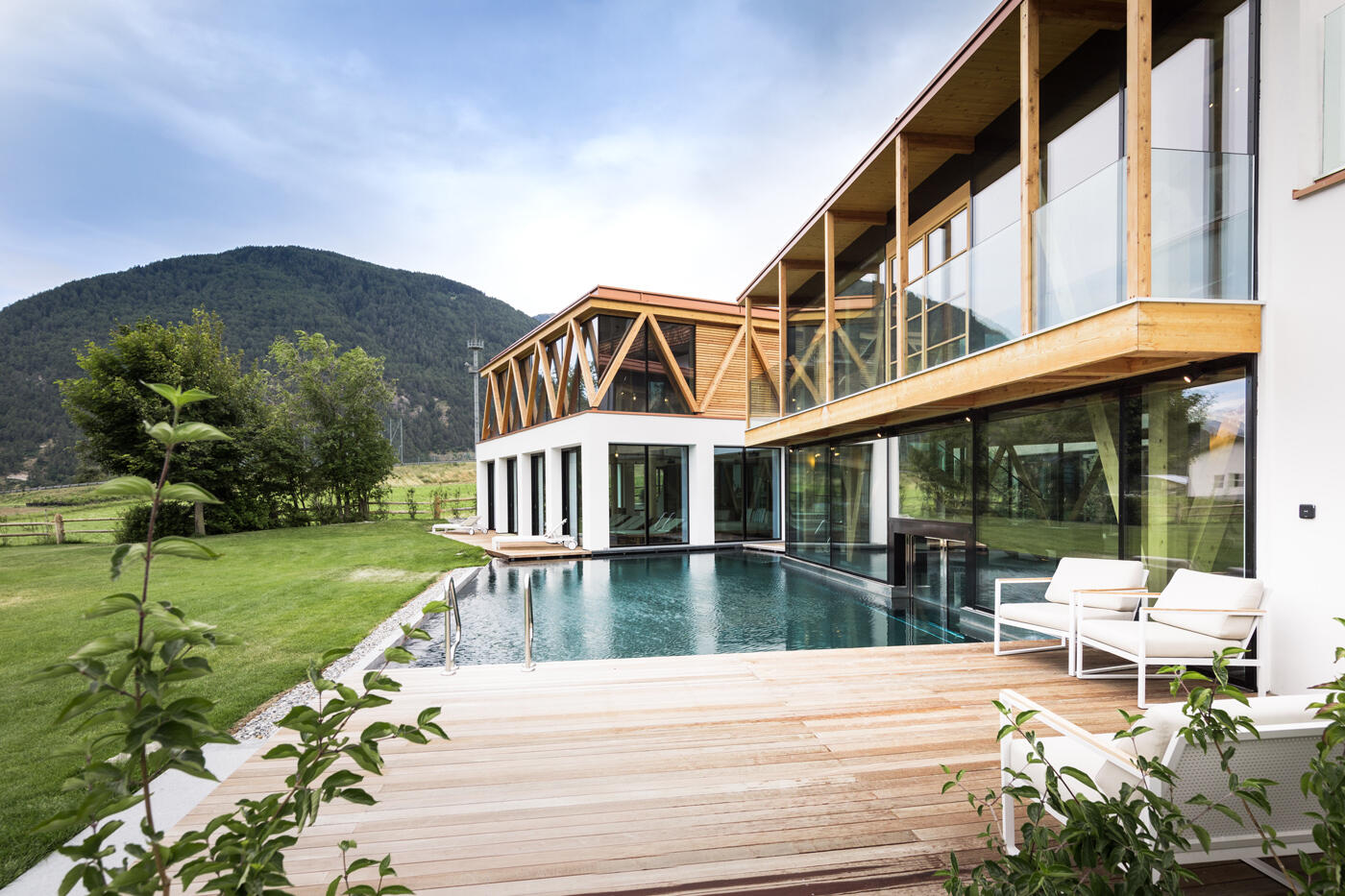 Verglastes Holzhaus mit Pool und Hölzerner Terrasse.