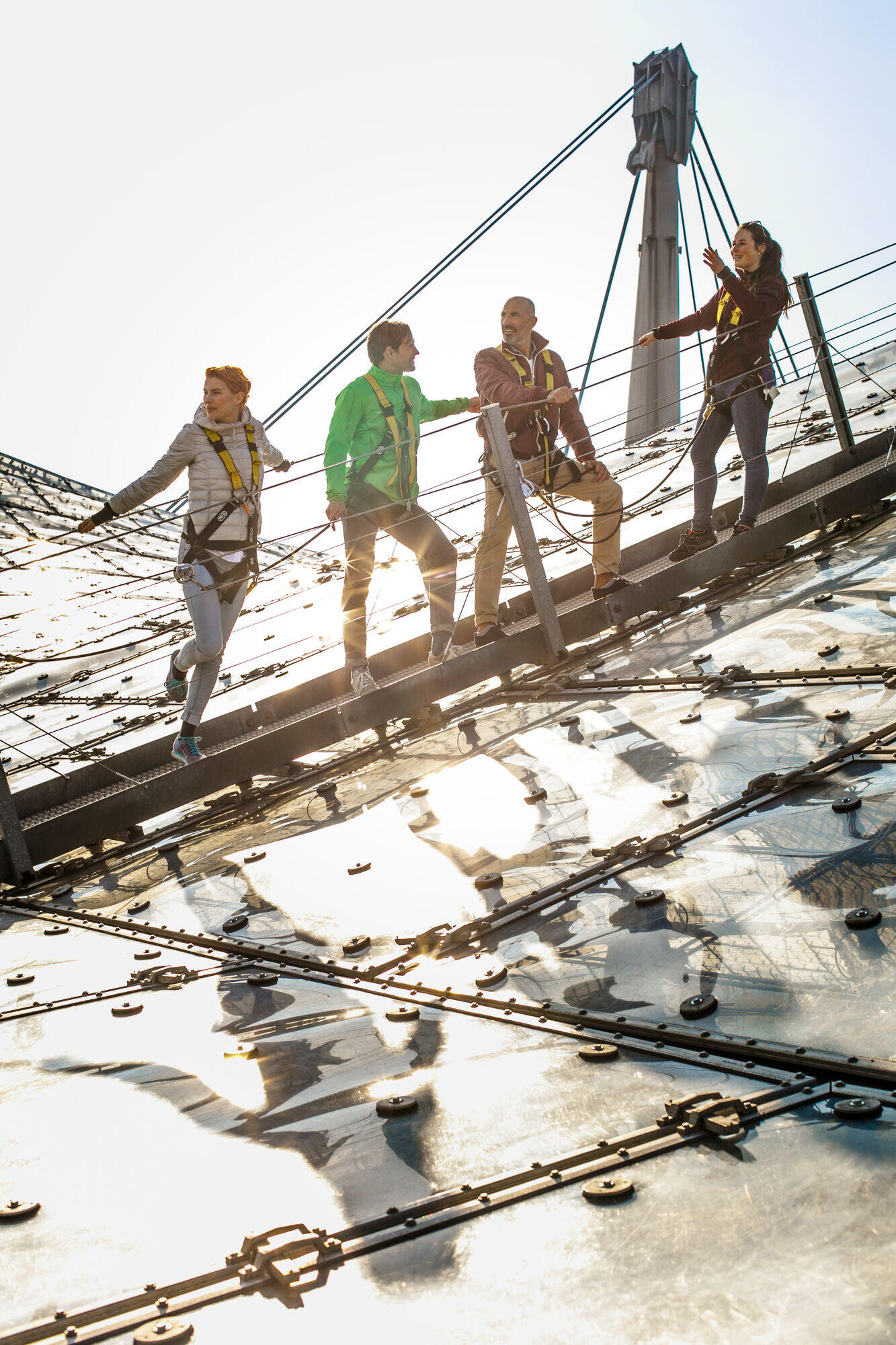 Menschen auf einem Dach: Zeltdachtour im Münchner Olympiapark