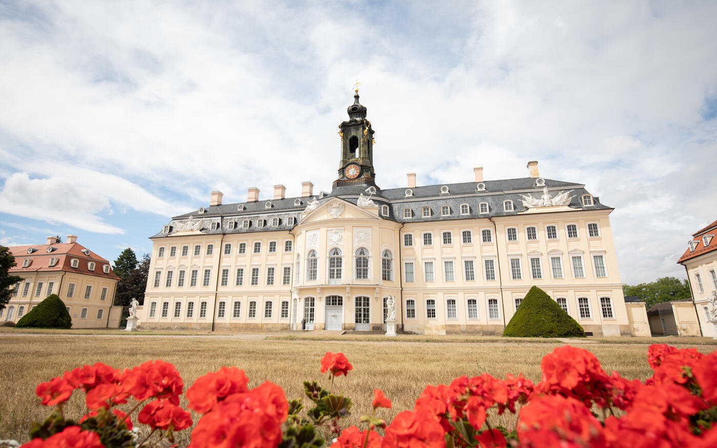 Burgen und Schlösser nahe Leipzig: Großes Schloss mit roten Blumen und Schlossgarten im Vordergrund
