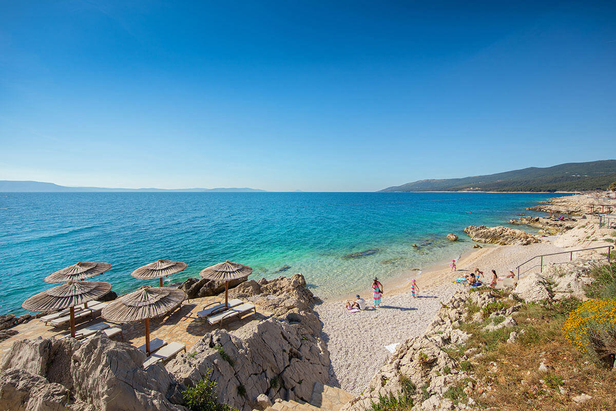Strand in Istrien mit Menschen und Liegen