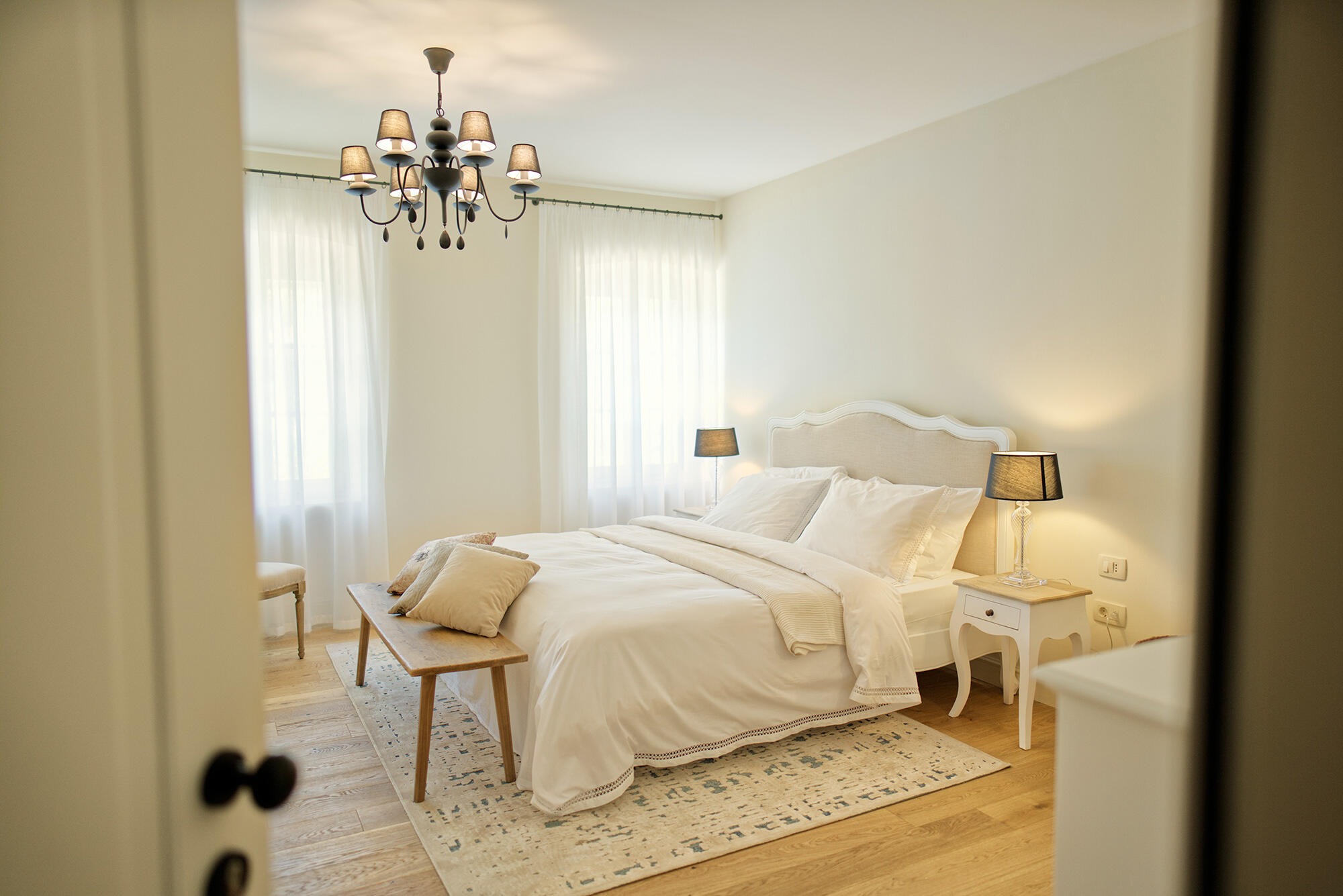 Weißes Doppelbett im eleganten Design im Schlafzimmer der Villa Majda