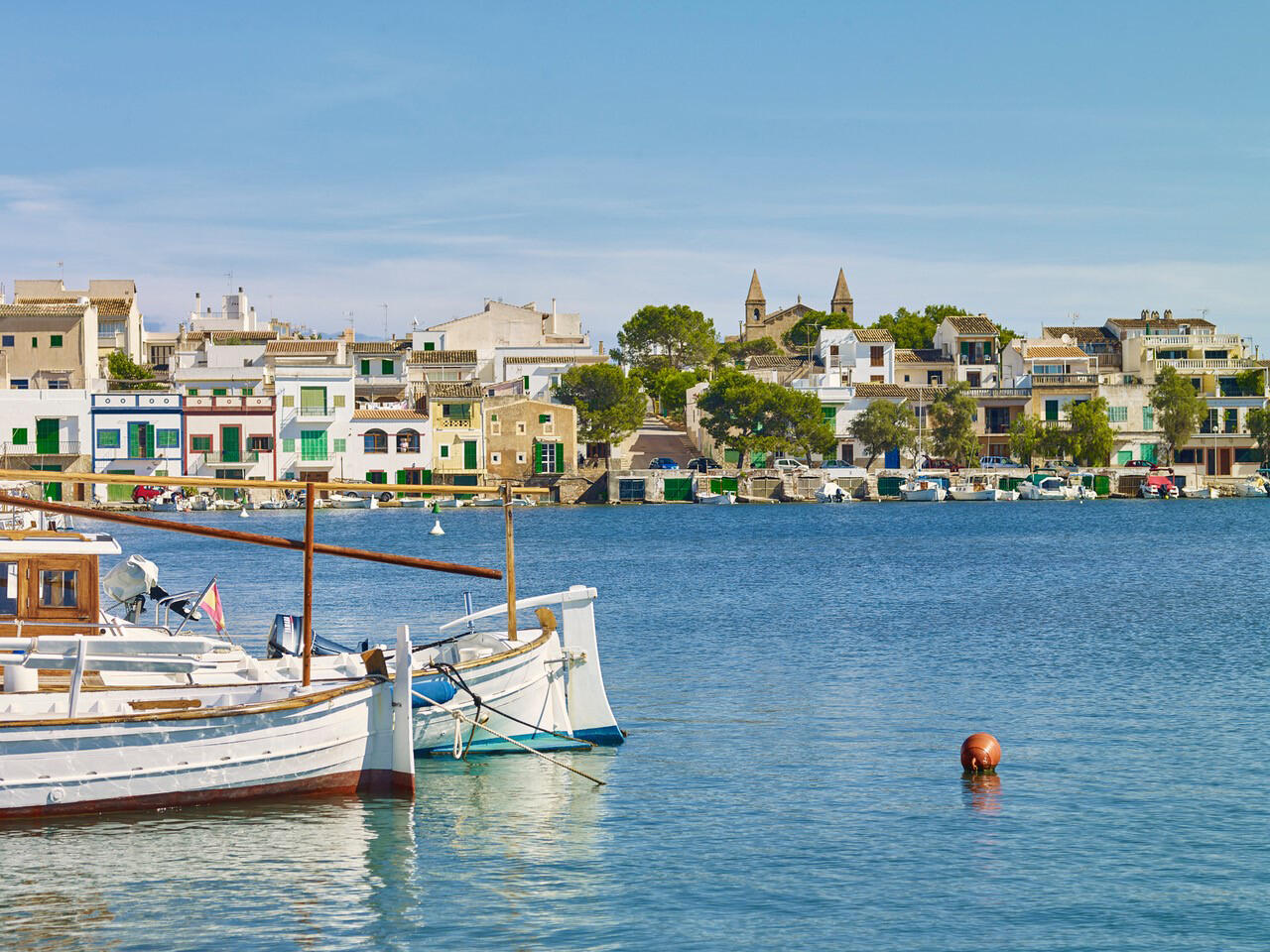 Portocolom auf Mallorca: Blick auf kleine Bucht mit Fischerboten und bunten Hausfassaden.
