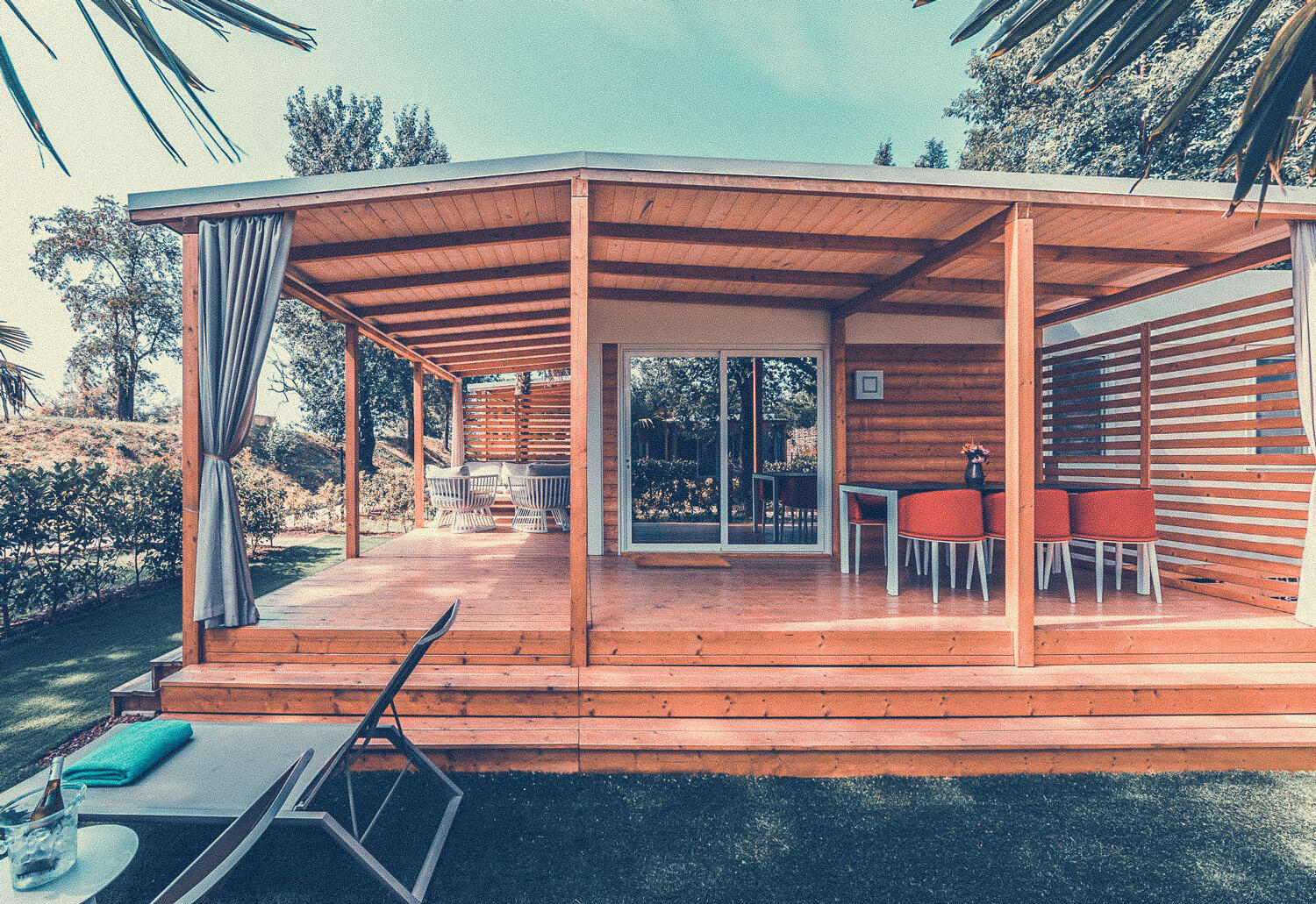 Tenuta Primero: Holzhaus mit großer Terrasse, der der rote Stühle stehen.