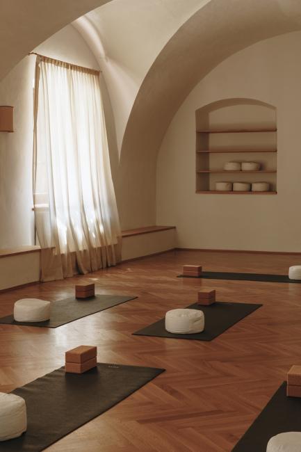 Yogaraum mit zugezogenem Vorhang und Yogamatten am Boden