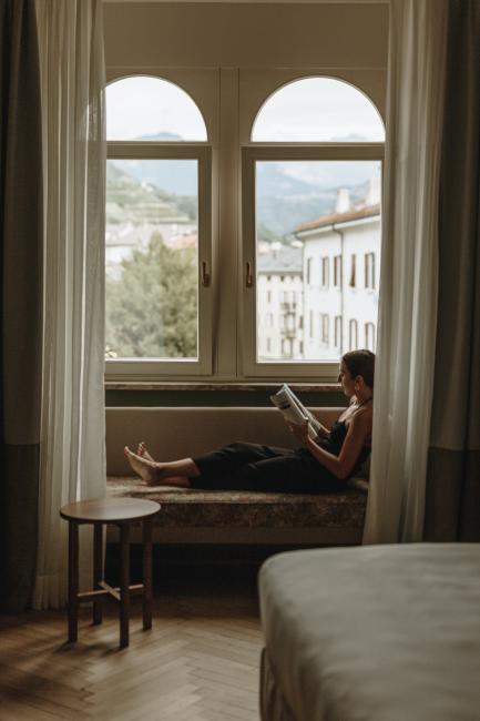 Frau, die auf einer Fensterbank sitzt und liest