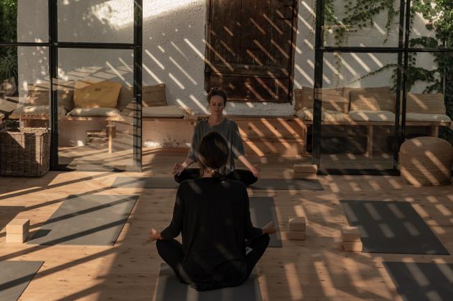 Zwei Frauen,die in einem Yogaraum meditieren
