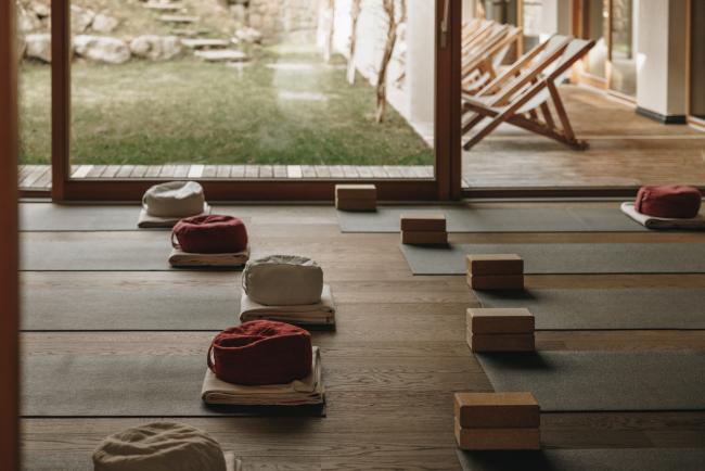 Yogaraum mit Matten, Blöcken und Sitzkissen auf dem Boden