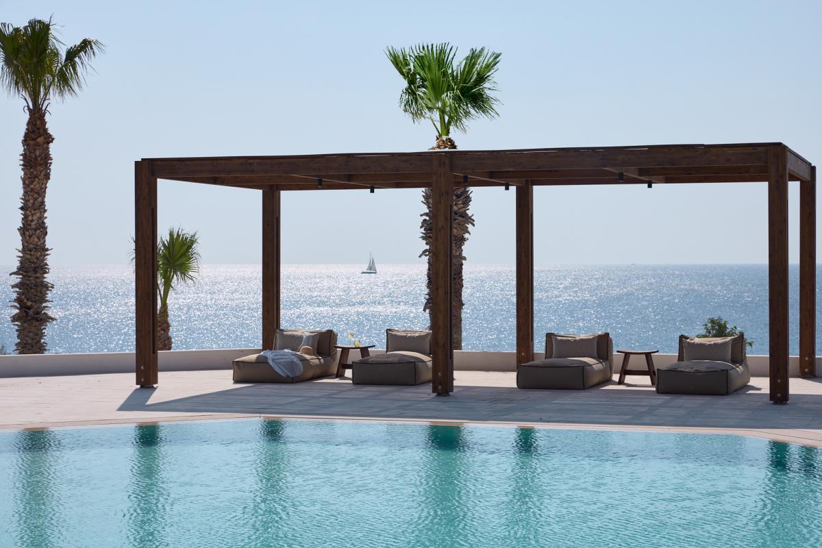 Pool im Elissa Lifestyleresort: Pool mit überdachter Liefefläche und Luegebetten. Im Hintergrund sieht man das Meer.