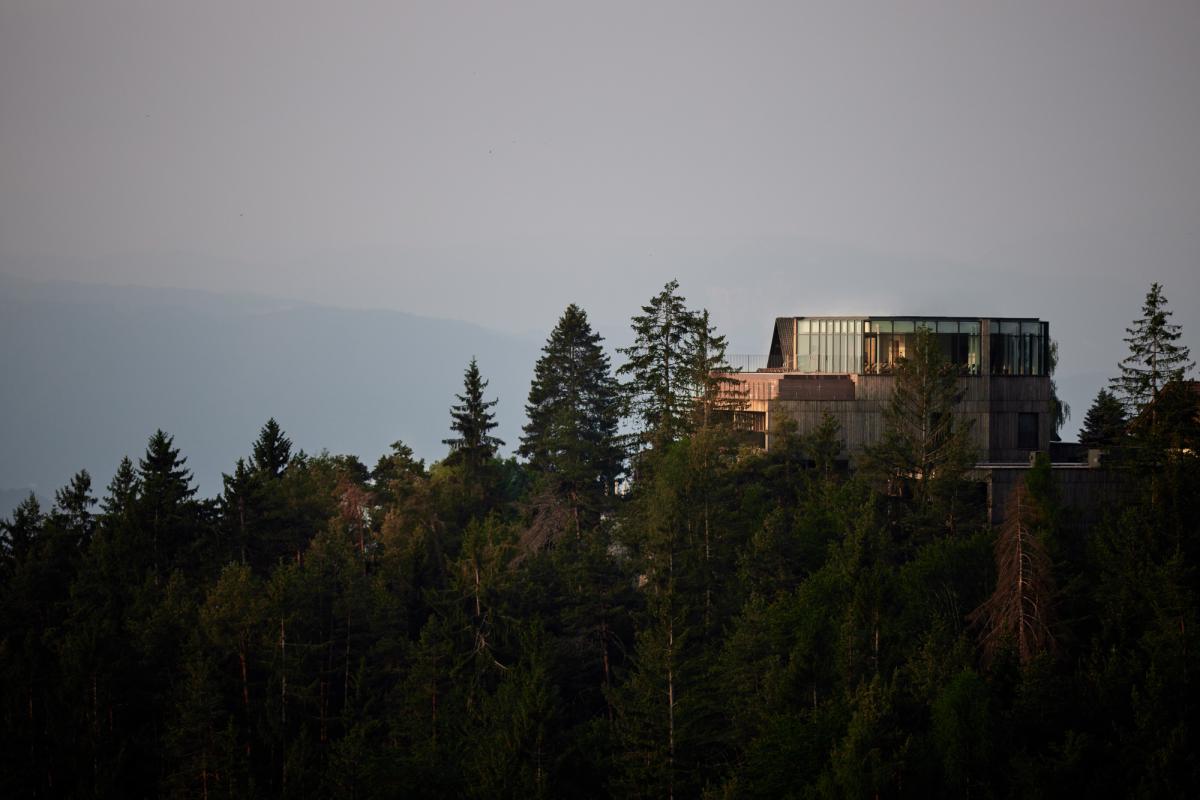 Waldhügel mit einem modernem Gebäude auf der Spitze